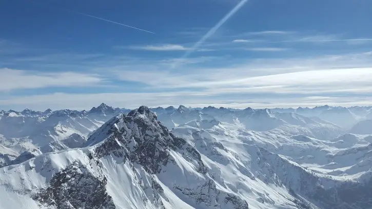 A breathtaking view of a snowy valley surrounded by majestic mountains, symbolizing limitless opportunities and exploration