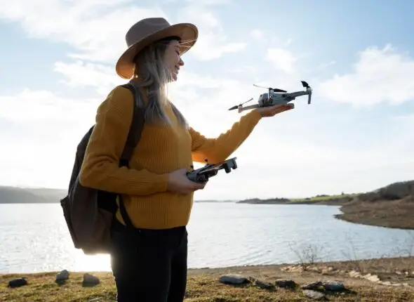 A female student holding a drone and smiling during hands-on training at Smart Drone Academy.